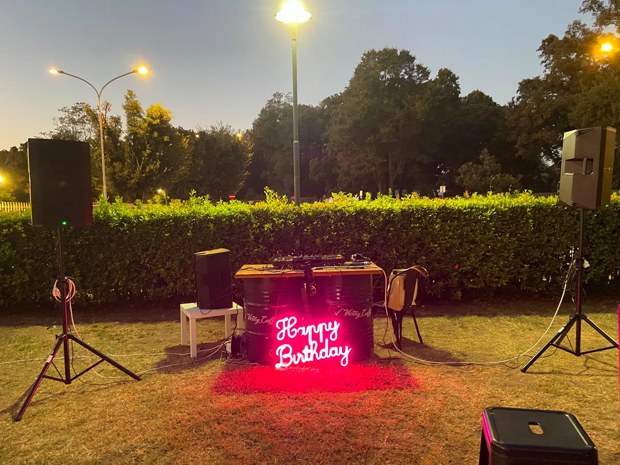 Postazione dj con l’insegna luminosa Happy Birthday sul prato